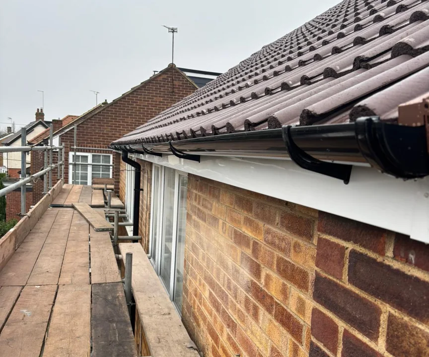 New tiles, white uPVC fascia and black guttering at the eaves of a re-roofed house